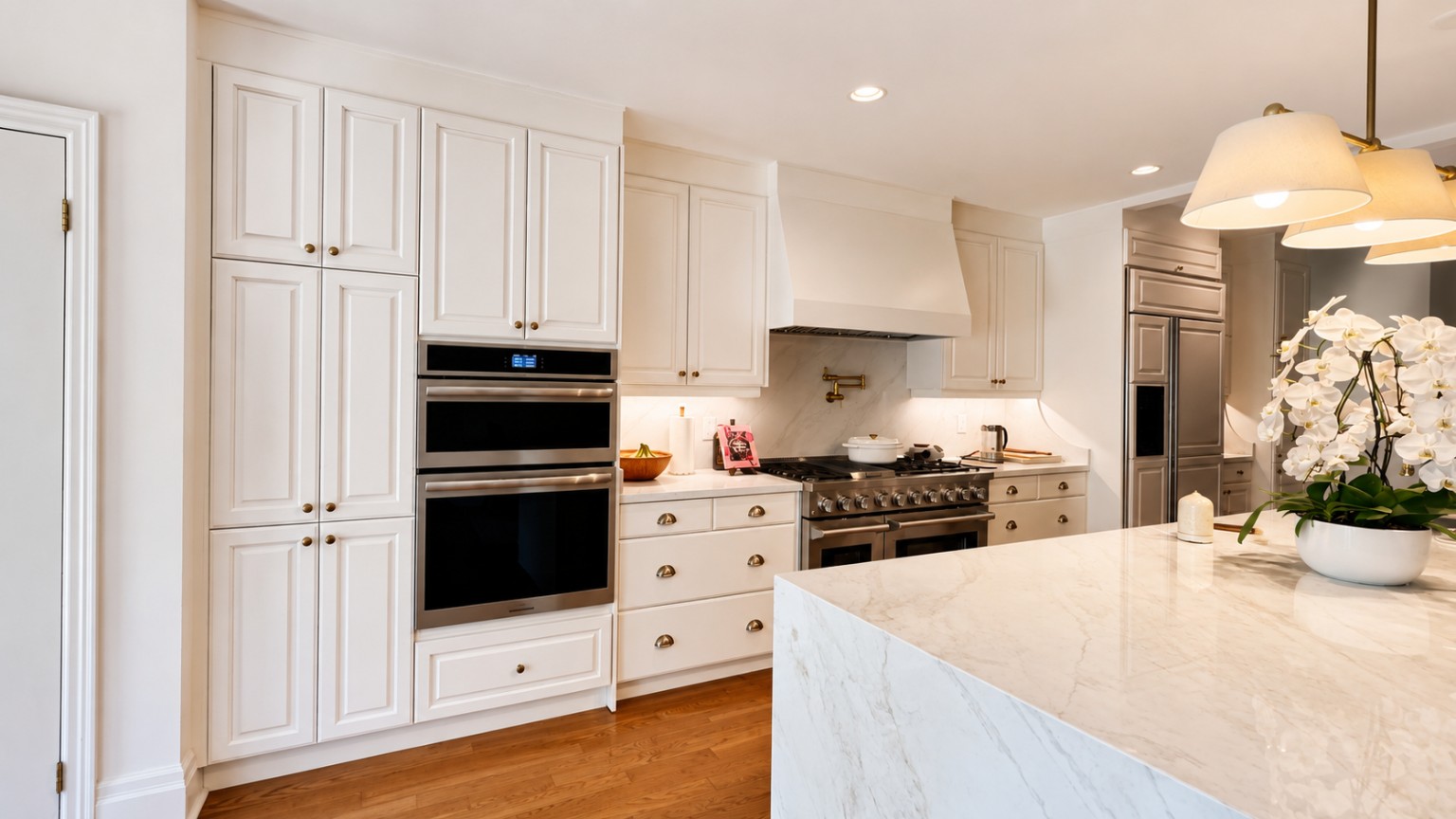 White kitchen cabinetry and stone island